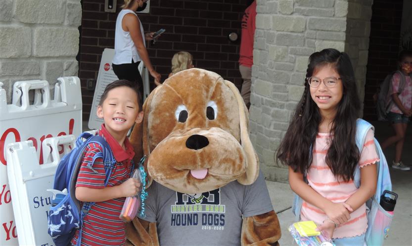 Students smile with a dog mascot